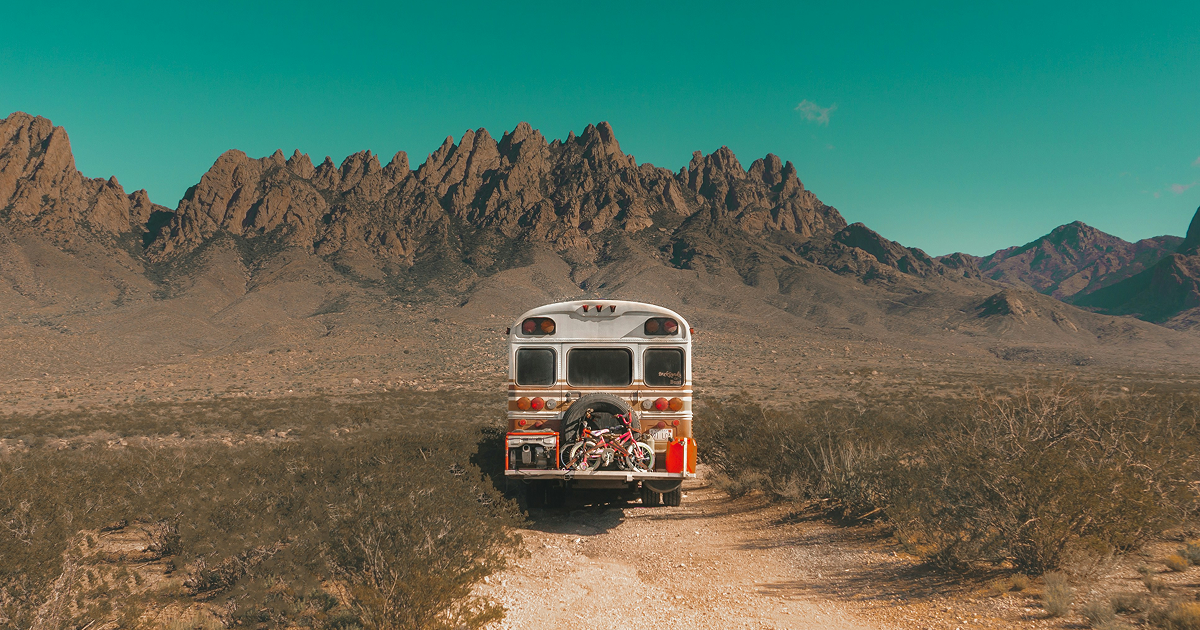 乾燥した砂漠の一本道に佇むキャンピングバス