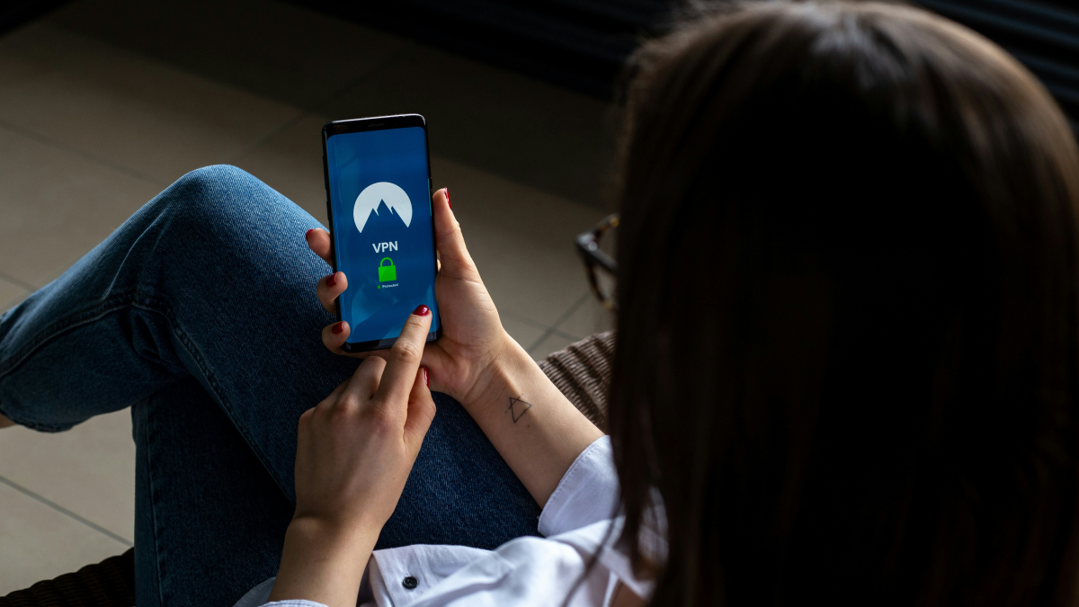 VPNアプリを開いたスマートフォンを操作する手元