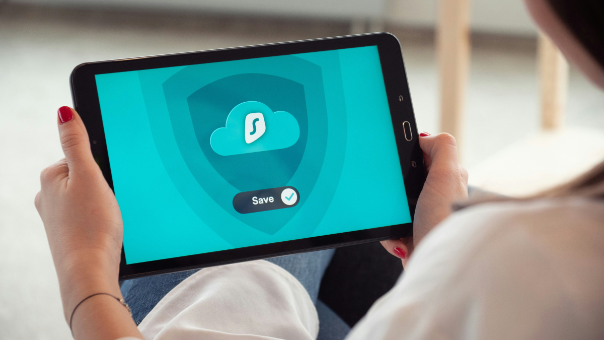 VPNアプリを表示したタブレットを持つ手元
